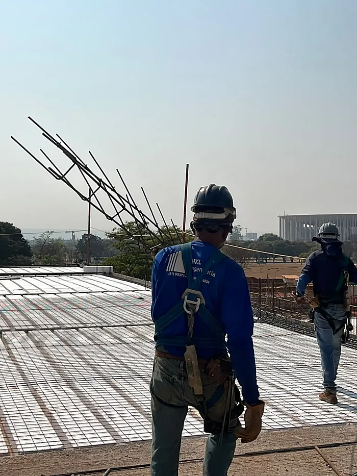 Equipe da MKL Engenharia em obra, de uniforme, capacete e cinto de segurança