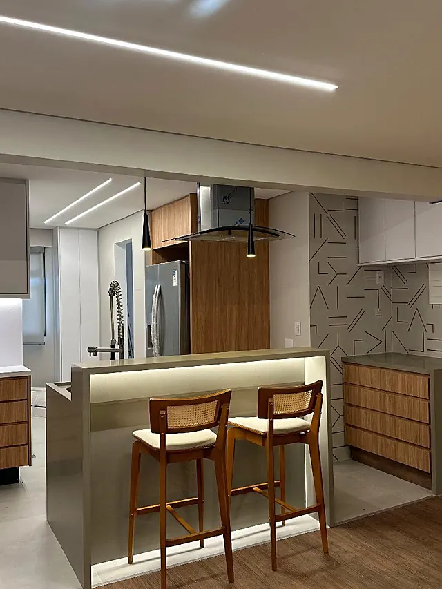 Estar integrado à cozinha, com bancada e banquetas